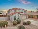 A charming two-story home with a red tile roof, stucco exterior, arched windows, desert landscaping and an attached two-car garage at 647 E Palomino Way, San Tan Valley, AZ 85143