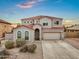 Charming two-story home with a red tile roof, stucco exterior, arched windows, desert landscaping and an attached two-car garage at 647 E Palomino Way, San Tan Valley, AZ 85143