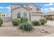 Two story home with desert landscaping, decorative rock, and a long driveway leading to a two car garage at 647 E Palomino Way, San Tan Valley, AZ 85143