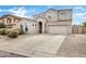 Charming two-story home with desert landscaping, decorative rock, and a long driveway leading to a two-car garage at 647 E Palomino Way, San Tan Valley, AZ 85143
