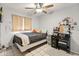 Cozy bedroom with a ceiling fan, a comfortable bed with many decorative items, and a vanity at 7546 E Clovis Cir, Mesa, AZ 85208