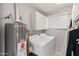 Laundry room area with a water heater, cabinets, and a washer and dryer set at 7546 E Clovis Cir, Mesa, AZ 85208