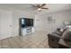 Bright living room featuring tile floors, a ceiling fan, and a comfortable gray sofa at 7546 E Clovis Cir, Mesa, AZ 85208