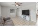 Bright living room featuring tile floors, a ceiling fan, and a comfortable gray sofa at 7546 E Clovis Cir, Mesa, AZ 85208