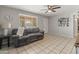 Bright living room featuring tile floors, a ceiling fan, and a comfortable gray sofa at 7546 E Clovis Cir, Mesa, AZ 85208
