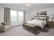 Well-lit bedroom featuring carpeted floors, neutral colors, modern furnishings, and two windows overlooking the landscape at 11737 N Richards Dr, Maricopa, AZ 85139