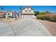 Front view of home with a spacious driveway and desert landscaping at 1202 W Sand Hills Ct, Gilbert, AZ 85233