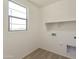 Functional laundry room with a window, utility connections, and shelving for storage and organization at 12738 N 172Nd Dr, Surprise, AZ 85388