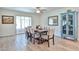 Bright dining area featuring a large dining table and a charming blue cabinet by a picture window at 12834 W Ashwood Dr, Sun City West, AZ 85375