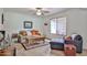 Bright living room features wood tile flooring, and comfortable seating with accents of pillows and a rug at 12834 W Ashwood Dr, Sun City West, AZ 85375