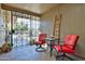 Charming patio featuring decorative ironwork, red seating, and a cozy setting, perfect for relaxing and enjoying the outdoors at 12834 W Ashwood Dr, Sun City West, AZ 85375