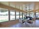 Bright sunroom surrounded by windows, offering panoramic views of the golf course, and perfect for dining and relaxation at 12834 W Ashwood Dr, Sun City West, AZ 85375