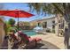 Resort-style backyard features a sparkling pool, mature landscaping, lounge seating, and umbrellas at 12873 N 175Th Dr, Surprise, AZ 85388