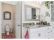 Bathroom features white cabinets, granite countertops, a decorative mirror and a view into the toilet room at 12873 N 175Th Dr, Surprise, AZ 85388
