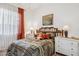 Cozy bedroom with a wood frame bed, colorful patterned bedding, and a sunlit window creating a warm ambiance at 12873 N 175Th Dr, Surprise, AZ 85388