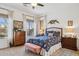 Charming bedroom with a patterned bedspread, wooden dresser, and soft natural light at 12873 N 175Th Dr, Surprise, AZ 85388