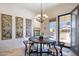 Bright dining area featuring a modern chandelier, wall art, and sliding glass doors to the patio at 12873 N 175Th Dr, Surprise, AZ 85388
