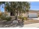 Well-maintained front yard with desert landscaping, a large shade tree, and a gravel lawn at 12873 N 175Th Dr, Surprise, AZ 85388