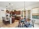 Well-lit kitchen with dark wood cabinets, granite countertops, and a breakfast bar adjacent to the dining area at 12873 N 175Th Dr, Surprise, AZ 85388