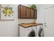 Bright laundry room features front loading washer and dryer, wood countertop, and upper storage cabinets at 12873 N 175Th Dr, Surprise, AZ 85388