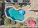 Aerial view of kidney-shaped pool with umbrellas, surrounded by desert landscaping and concrete patio at 12873 N 175Th Dr, Surprise, AZ 85388