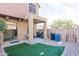 Fully fenced backyard features artificial grass and a covered patio, perfect for outdoor activities at 1350 S Greenfield Rd # 1016, Mesa, AZ 85206