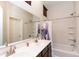 Well-lit bathroom featuring a double sink vanity and a shower/tub combo with a purple shower curtain at 1350 S Greenfield Rd # 1016, Mesa, AZ 85206