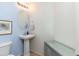 Stylish powder room with pedestal sink, round mirror, and neutral color scheme at 1350 S Greenfield Rd # 1016, Mesa, AZ 85206