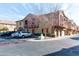 Charming townhome with a red door, a tree in the yard, and multiple parking spaces at 1350 S Greenfield Rd # 1016, Mesa, AZ 85206