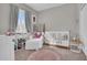 Adorable Bedroom featuring a white crib, comfortable seating, and playful decor at 155 N Lakeview Blvd # 206, Chandler, AZ 85225