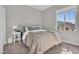Cozy bedroom with a tufted headboard, plush carpet, and natural light from a large window at 155 N Lakeview Blvd # 206, Chandler, AZ 85225