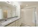Bright bathroom with granite counters, dual sinks, walk-in shower, and a convenient storage area at 18153 W Fulton St, Goodyear, AZ 85338