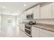Modern white kitchen with stainless steel appliances and granite countertops at 18153 W Fulton St, Goodyear, AZ 85338