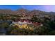 Stunning aerial view of estate home with red tile roof nestled in a lush landscape with mountain views at 19494 N 98Th Pl, Scottsdale, AZ 85255