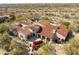 Elegant home with a circular entryway, red tile roof, and manicured desert landscaping from above at 19494 N 98Th Pl, Scottsdale, AZ 85255