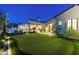 A manicured backyard with a putting green, and a luxurious outdoor living space with an inground pool and patio at 19494 N 98Th Pl, Scottsdale, AZ 85255