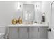 Bright bathroom featuring a modern vanity with a square mirror, elegant fixtures, and decorative gold accents at 19494 N 98Th Pl, Scottsdale, AZ 85255