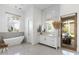 Elegant bathroom with a freestanding tub, vanity, and lots of natural light at 19494 N 98Th Pl, Scottsdale, AZ 85255