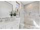 Bathroom features a white vanity and a glass-enclosed shower with marble tiling at 19494 N 98Th Pl, Scottsdale, AZ 85255