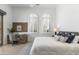 Relaxing bedroom with shuttered windows, wooden desk, and a comfortable bed with decorative pillows at 19494 N 98Th Pl, Scottsdale, AZ 85255