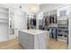Bright and spacious walk-in closet with an island and custom shelving at 19494 N 98Th Pl, Scottsdale, AZ 85255