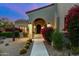 Charming front entrance with desert landscaping, a stone walkway, and architectural lighting, creating an inviting approach at 19494 N 98Th Pl, Scottsdale, AZ 85255