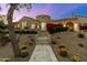 Stunning home featuring a neutral color scheme, desert landscaping, and red flowering bushes at 19494 N 98Th Pl, Scottsdale, AZ 85255