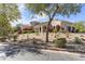 Lovely home with manicured desert landscaping, mature trees, and a paver driveway at 19494 N 98Th Pl, Scottsdale, AZ 85255