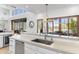 Bright kitchen boasts an island with stainless steel sink, and views to the outdoor living spaces at 19494 N 98Th Pl, Scottsdale, AZ 85255