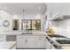 Modern kitchen with white cabinets, stainless steel appliances, stone countertops, and stylish lighting at 19494 N 98Th Pl, Scottsdale, AZ 85255