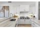 Contemporary kitchen with white cabinets, subway tile backsplash, stone counters, and Wolf range at 19494 N 98Th Pl, Scottsdale, AZ 85255