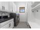 Bright laundry room with modern washer and dryer, cabinetry, a sink, and a convenient bench at 19494 N 98Th Pl, Scottsdale, AZ 85255