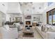 Open living room with a fireplace, comfortable seating, bar, and natural light at 19494 N 98Th Pl, Scottsdale, AZ 85255