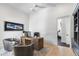 Well-lit home office with a rustic wooden desk, comfortable seating, and views of the adjacent fitness room at 19494 N 98Th Pl, Scottsdale, AZ 85255